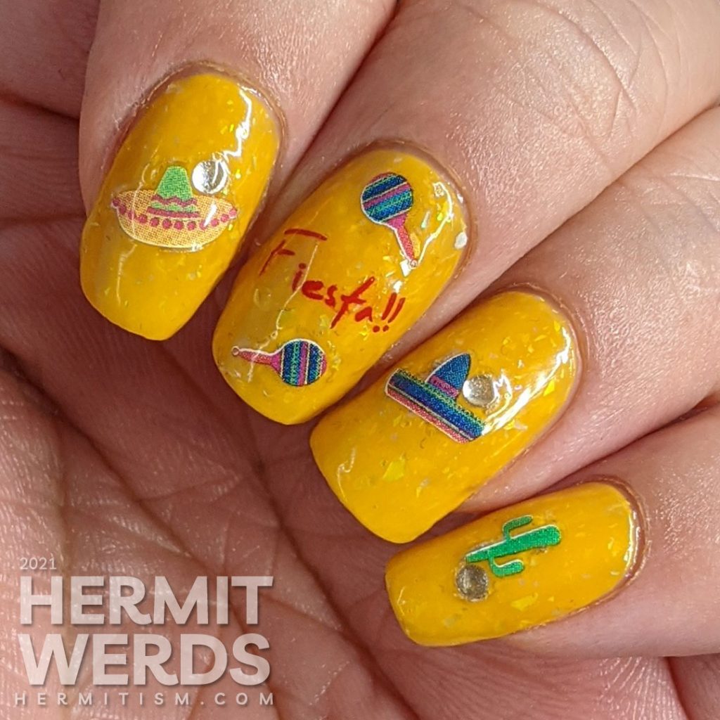 Mexico-related nail stickers (hot peppers, sombreros, maracas, and a cactus) with the word "fiesta" decorating a bright mustard crelly with iridescent flakes to celebrate Cinco de Mayo.