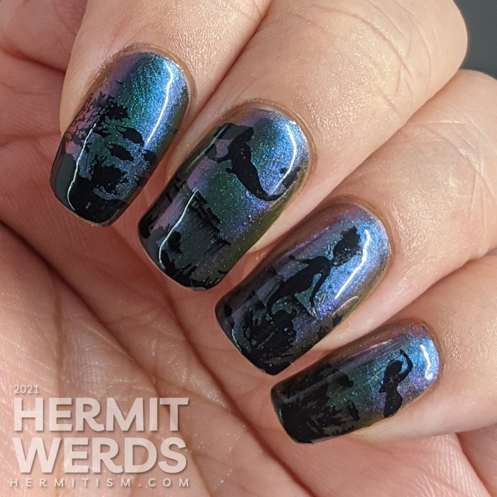 An ultra multichrome base polish from turquoise to purple to orange with ocean floor and swimming mermaids stamped on in black.