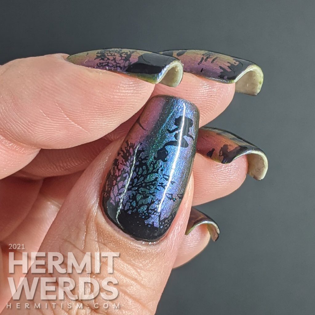 An ultra multichrome base polish from turquoise to purple to orange with ocean floor and swimming mermaids stamped on in black.