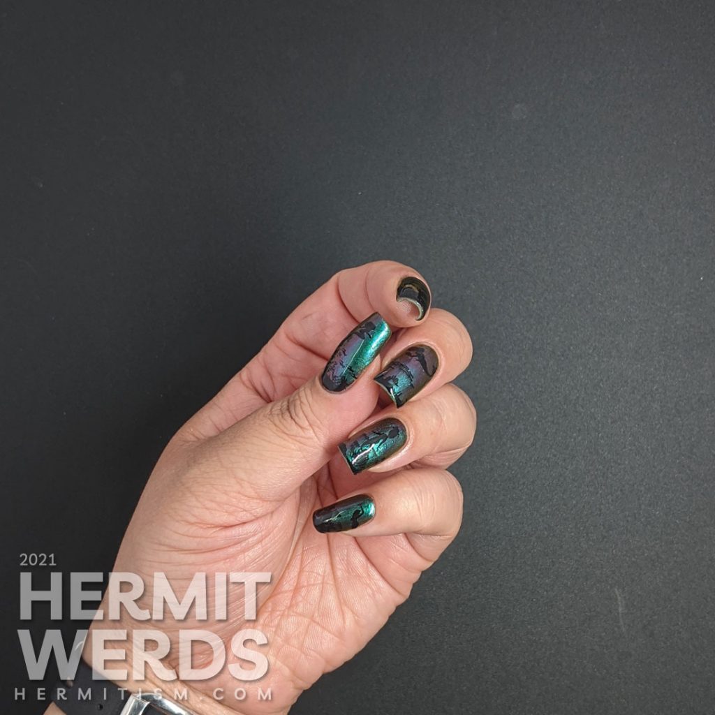 An ultra multichrome base polish from turquoise to purple to orange with ocean floor and swimming mermaids stamped on in black.