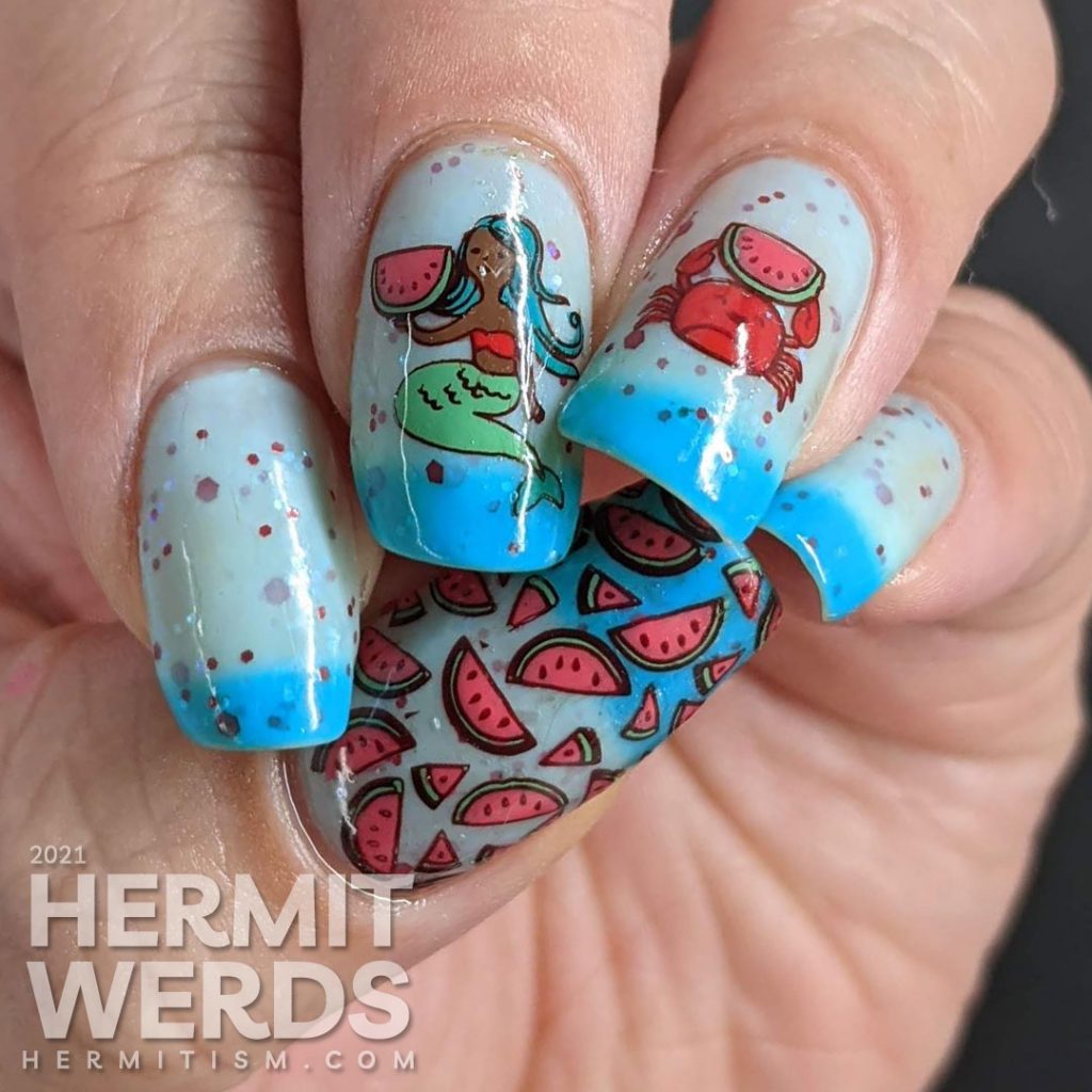 A turquoise to white thermal nail polish with stamping decals of a mermaid and crab enjoying watermelon and a full-nail watermelon pattern on the thumb.