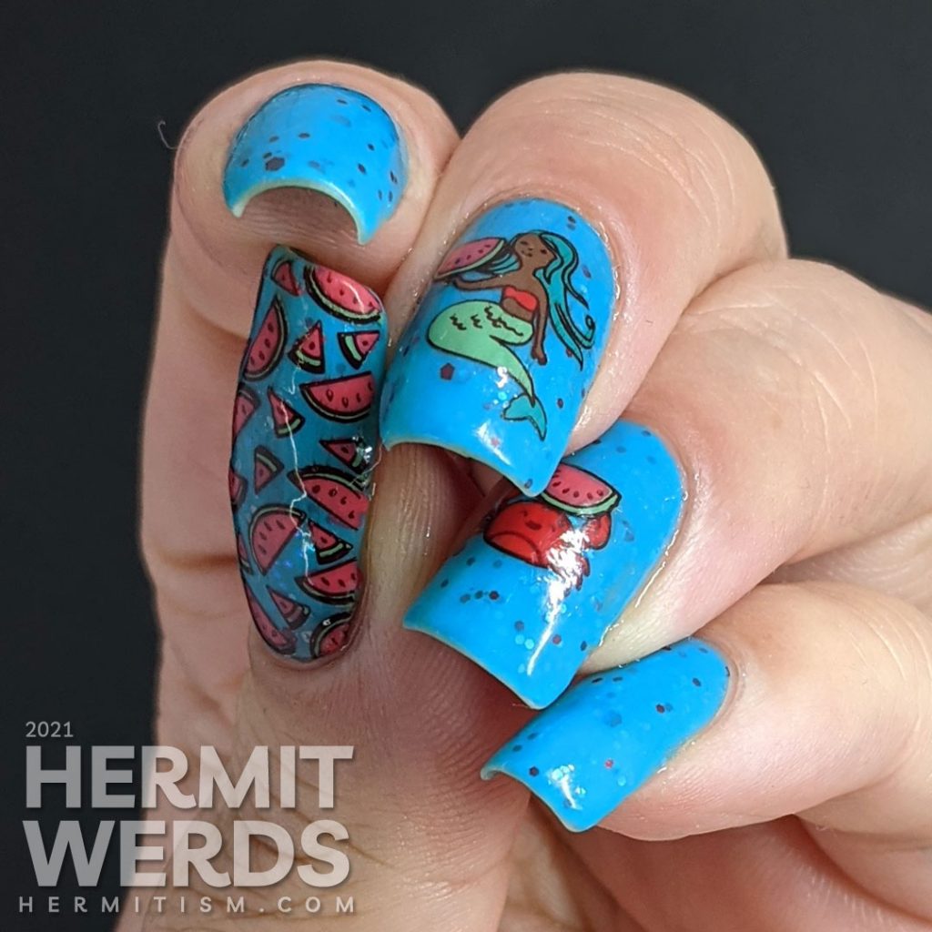 A turquoise to white thermal nail polish with stamping decals of a mermaid and crab enjoying watermelon and a full-nail watermelon pattern on the thumb.