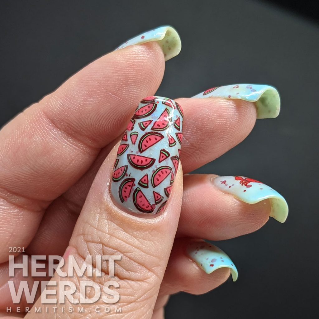 A turquoise to white thermal nail polish with stamping decals of a mermaid and crab enjoying watermelon and a full-nail watermelon pattern on the thumb.