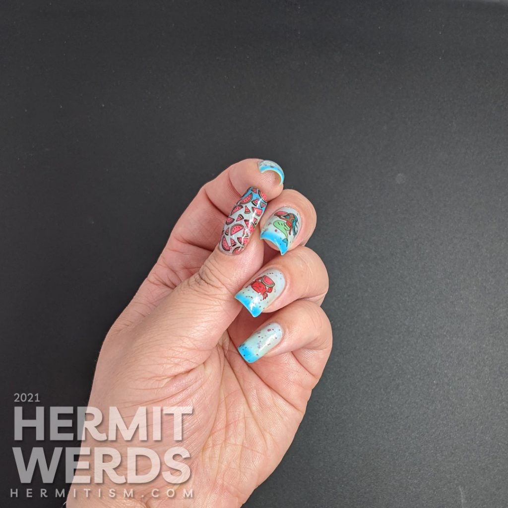 A turquoise to white thermal nail polish with stamping decals of a mermaid and crab enjoying watermelon and a full-nail watermelon pattern on the thumb.