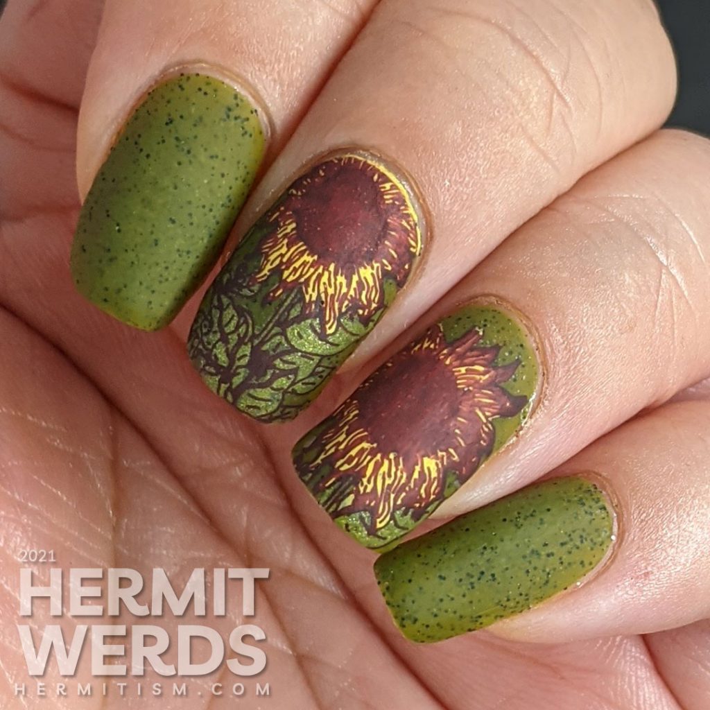 Autumn-esque nail art of yellow, orange, and brown sunflower stamping decals on an olive green speckled nail polish base.