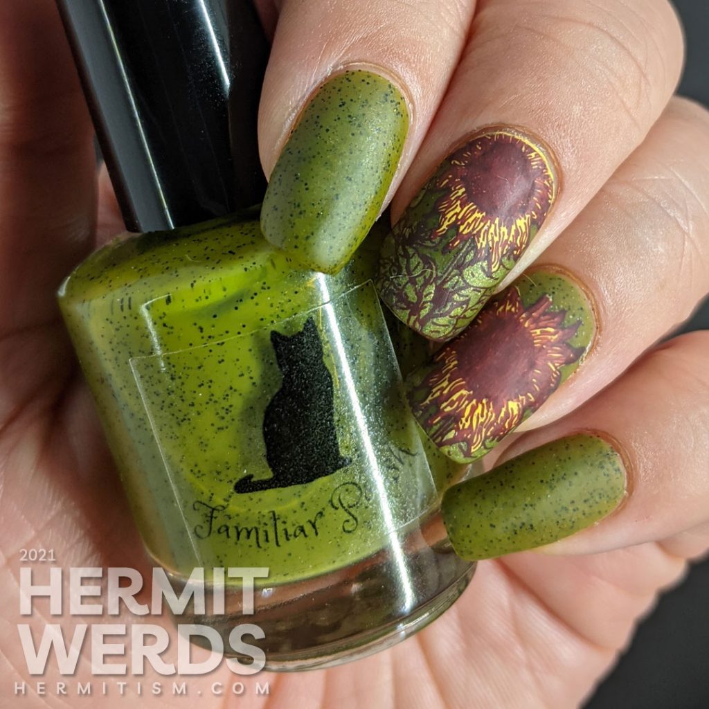 Autumn-esque nail art of yellow, orange, and brown sunflower stamping decals on an olive green speckled nail polish base.