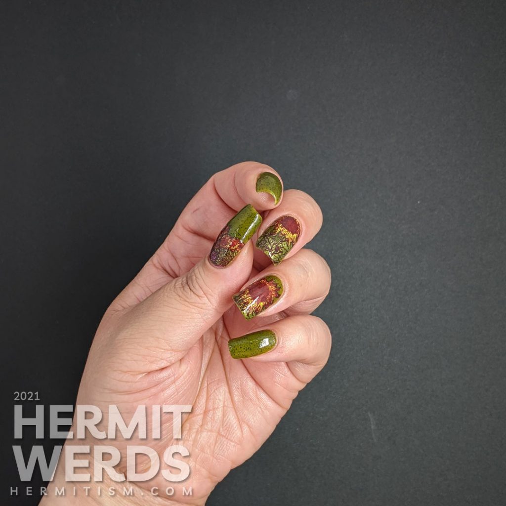 Autumn-esque nail art of yellow, orange, and brown sunflower stamping decals on an olive green speckled nail polish base.