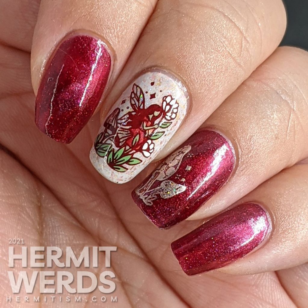 A red magnetic nail art with soft rose gold crelly accent nails and stamping decals of fairies, mushrooms, and flora.