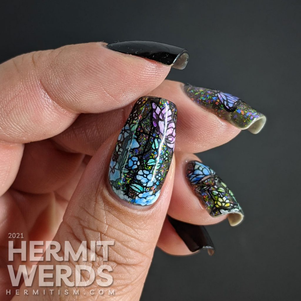 A stained glass butterfly nail art with an iridescent flakie topper and watercolor paint to fill in the butterfly decals.