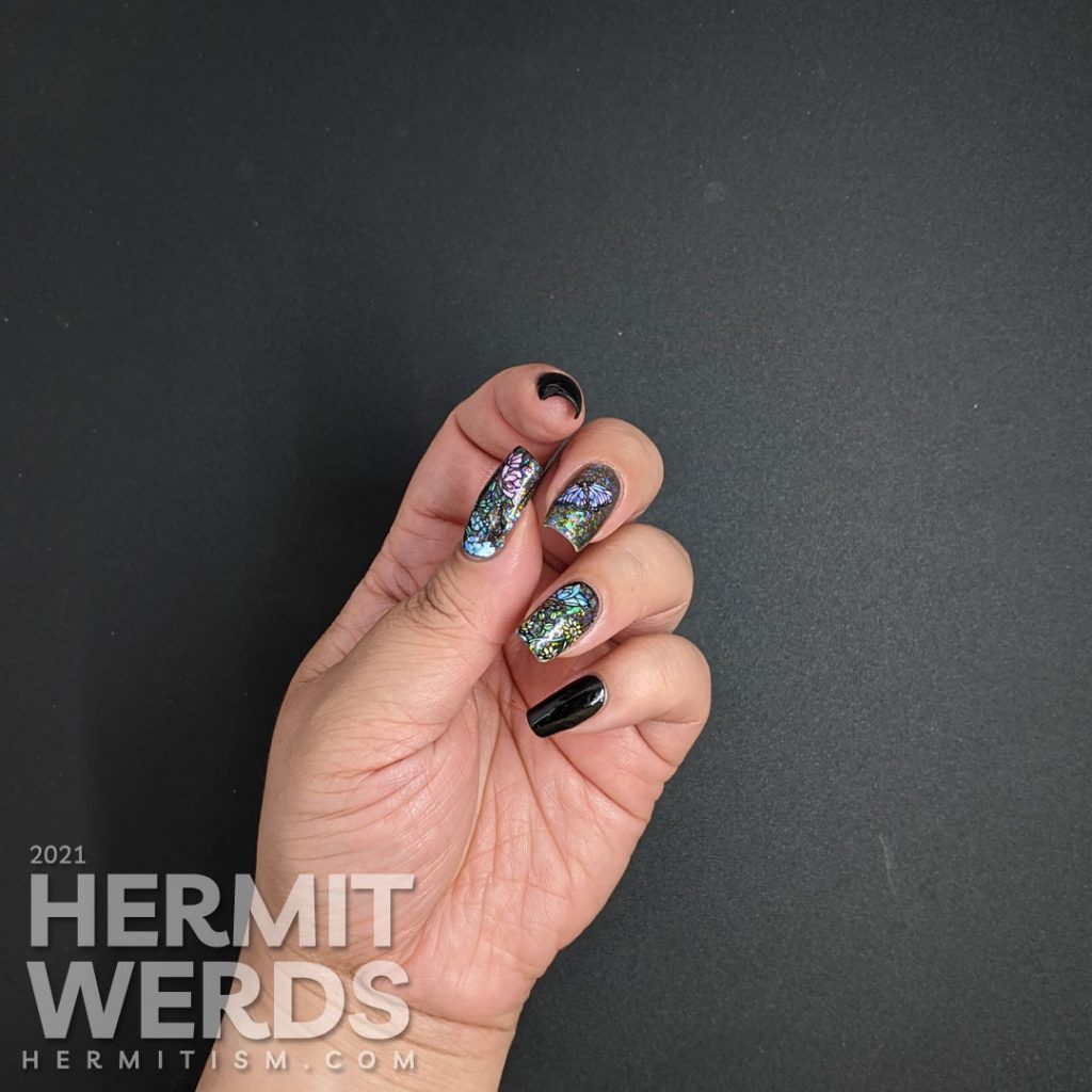 A stained glass butterfly nail art with an iridescent flakie topper and watercolor paint to fill in the butterfly decals.