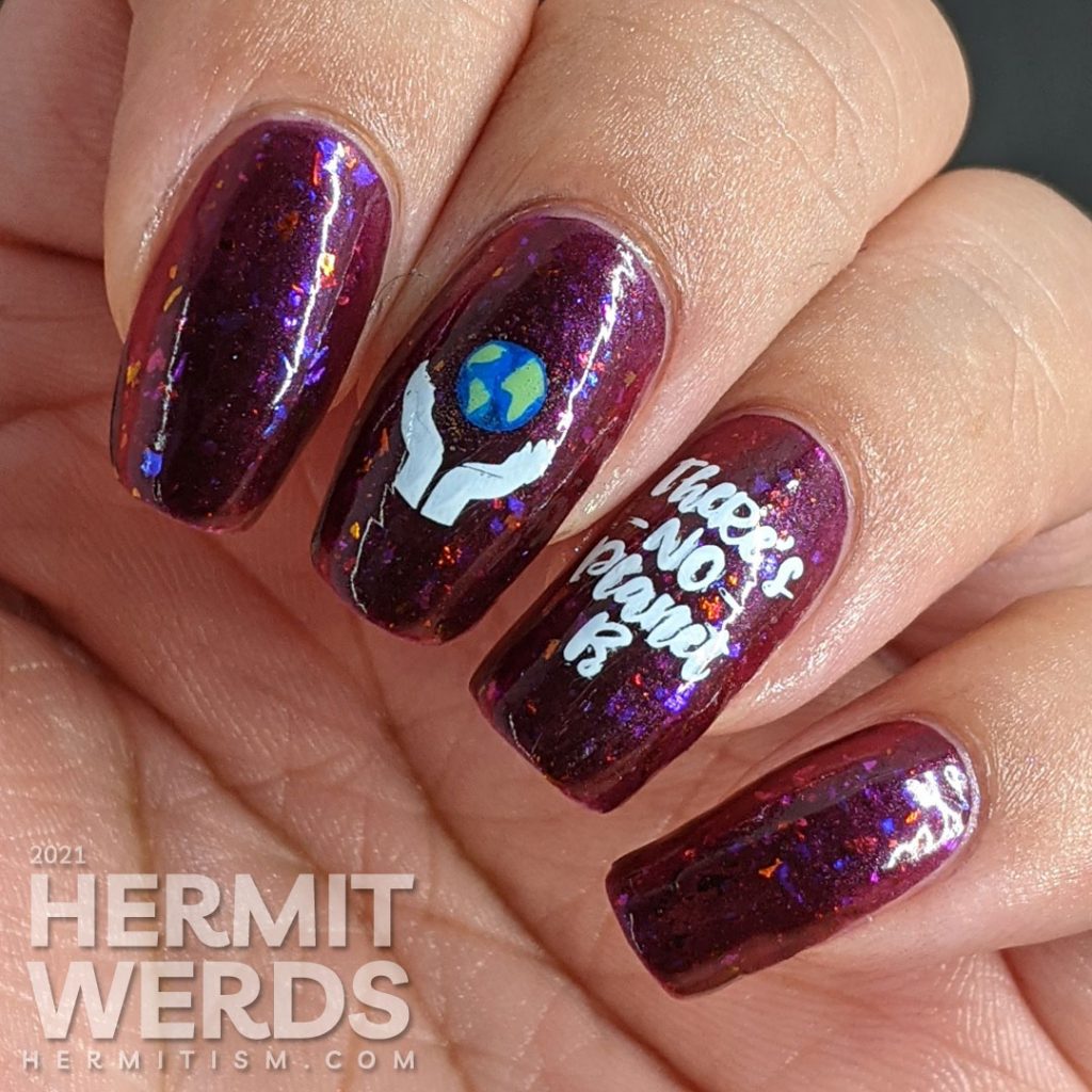 A plum flakie filled polish with earth-loving stamping images on top and a surprise nuclear explosion blowing up the planet. Oops!