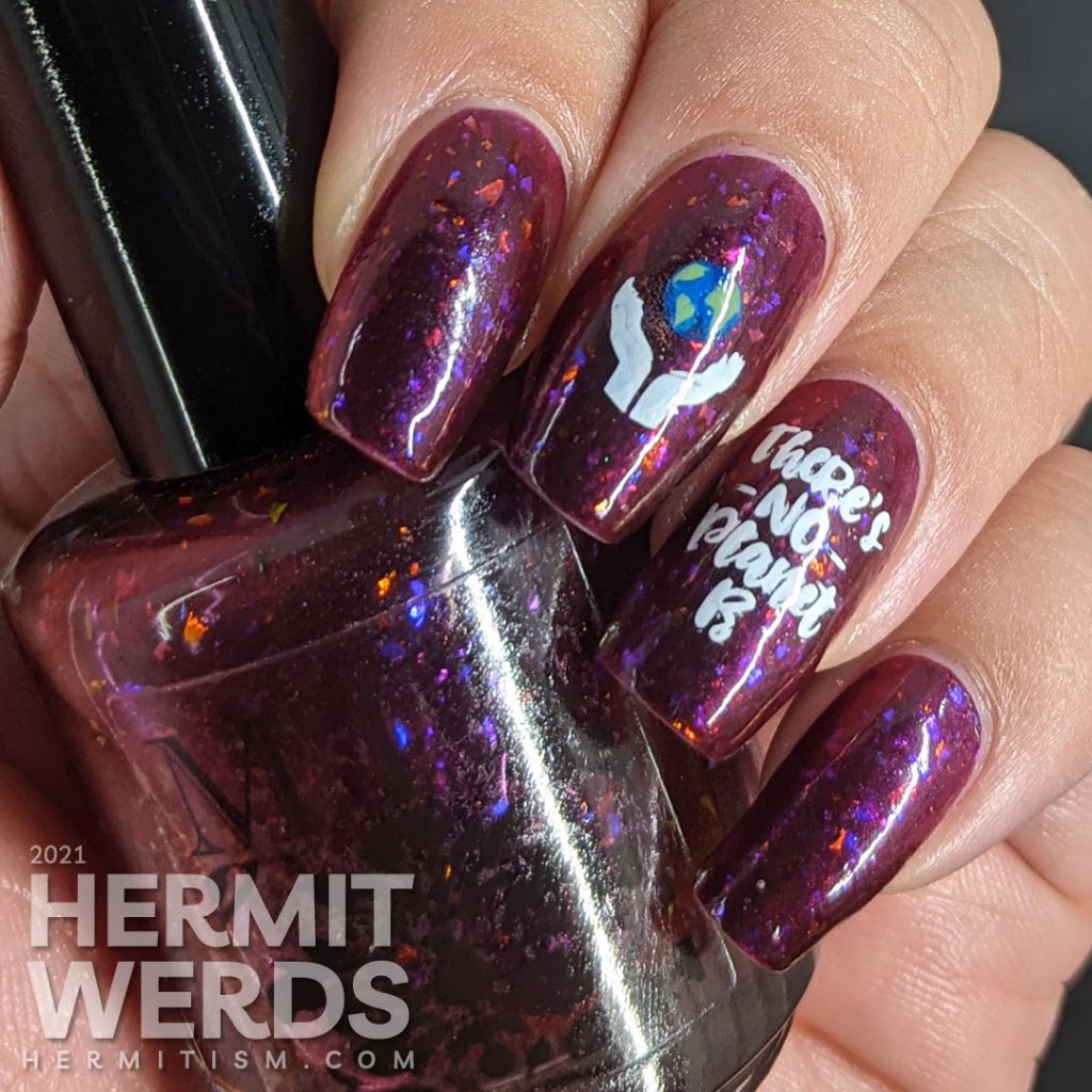 A plum flakie filled polish with earth-loving stamping images on top and a surprise nuclear explosion blowing up the planet. Oops!