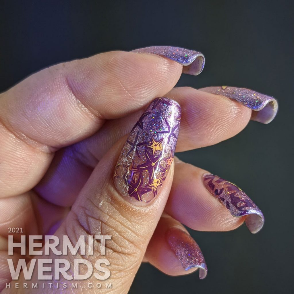 A purple baby boomer French tip nail art with a solar holographic glitter polish and starfish stamping decals on top.