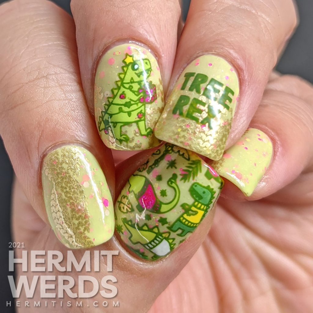 Christmas nail art with stamping decals of Tree Rex & dinosaurs in cozy sweaters in neon pink, green, yellow, and white on a green crelly.