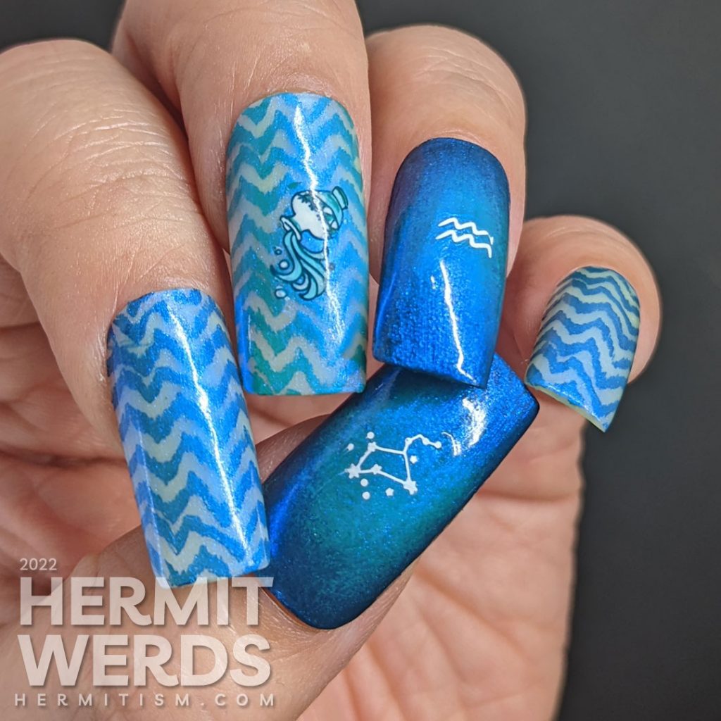 An aquarius/zodiac themed nail art with lots of blue chevrons and nail stamping images of Aquarius symbols.