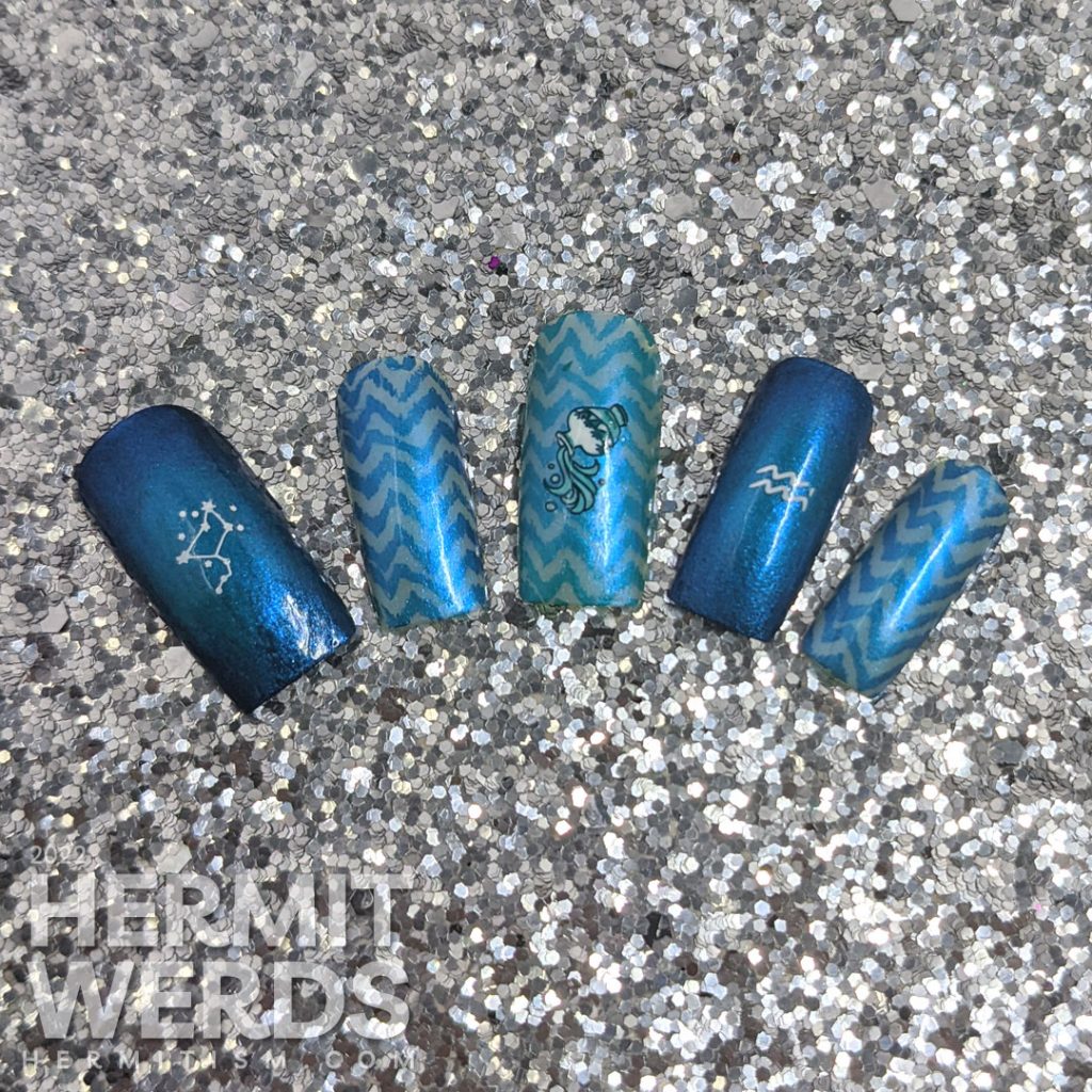 An aquarius/zodiac themed nail art with lots of blue chevrons and nail stamping images of Aquarius symbols.