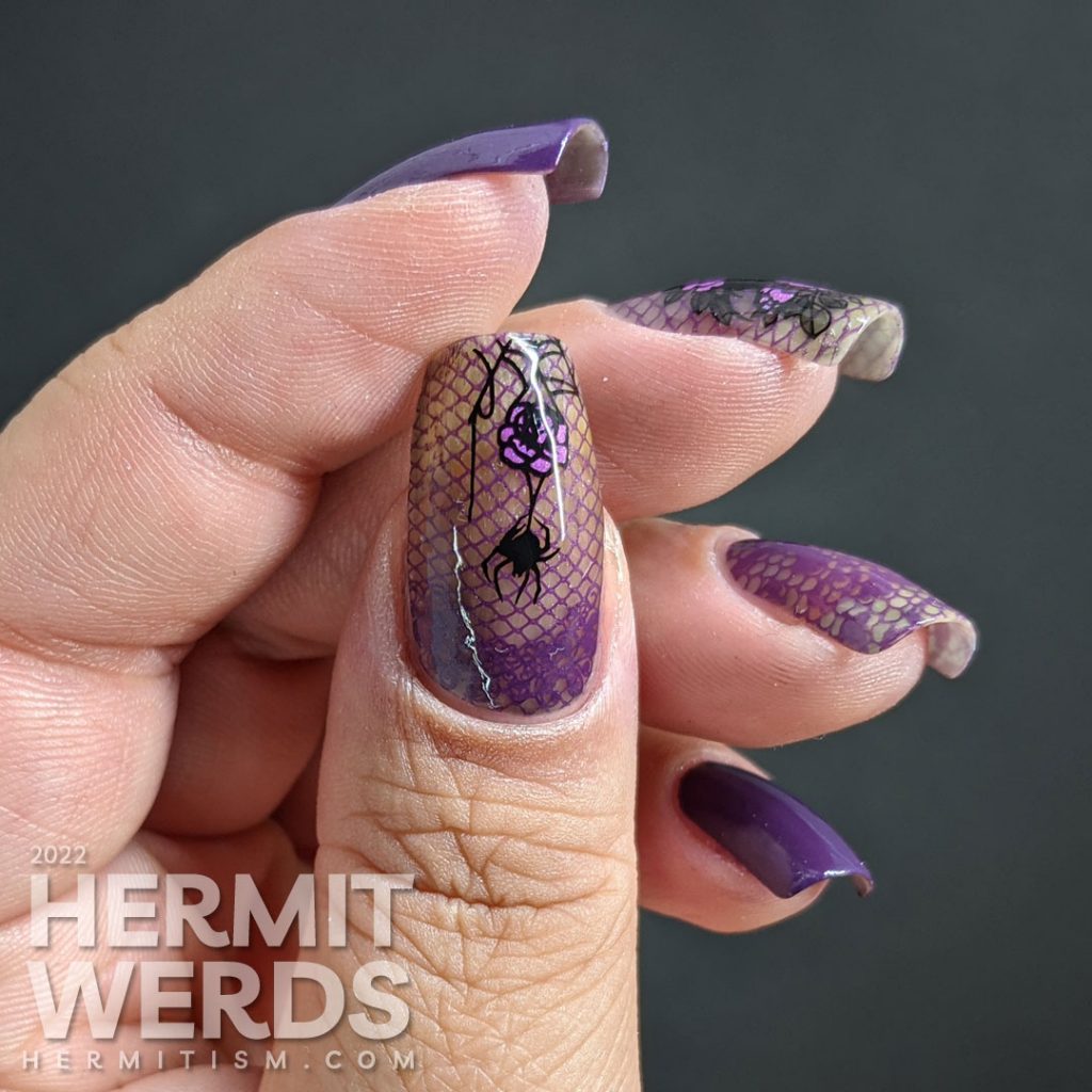A gothic purple spider mani with lacy purple accent nails decorated with rose, spider, and lace stamping decals.