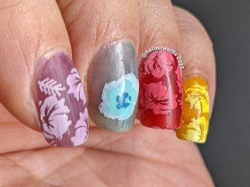 A rainbow skittle pond nail art with hibiscus stamping decals sandwiched in layers of red, purple, blue, yellow, and orange jelly polish.