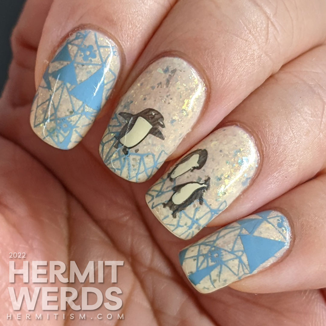 Soft penguin nail art with metallic black stamping images of fanciful penguins and grey-blue geometric ice patterns.