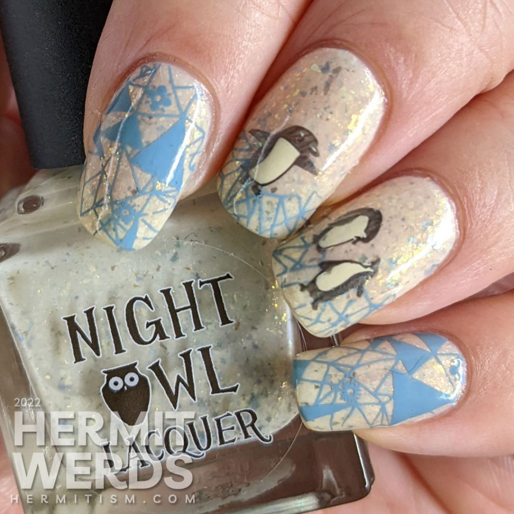 Soft penguin nail art with metallic black stamping images of fanciful penguins and grey-blue geometric ice patterns.