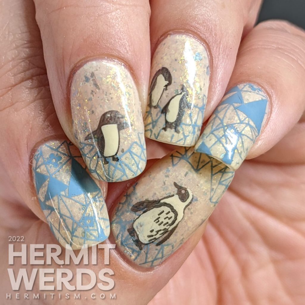 Soft penguin nail art with metallic black stamping images of fanciful penguins and grey-blue geometric ice patterns.