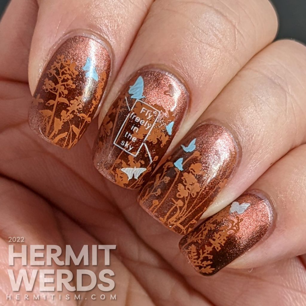 A coppery-y floral mani with a magnetic copper base and simple stamping images of a floral field and tiny baby blue and white butterflies.