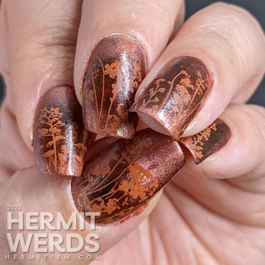 A coppery-y floral mani with a magnetic copper base and simple stamping images of a floral field and tiny baby blue and white butterflies.