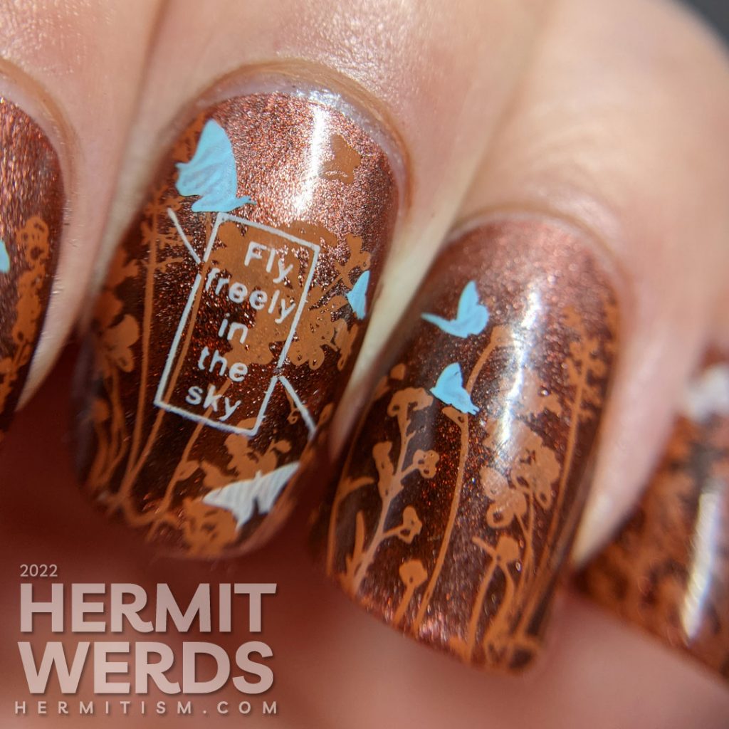 A coppery-y floral mani with a magnetic copper base and simple stamping images of a floral field and tiny baby blue and white butterflies.
