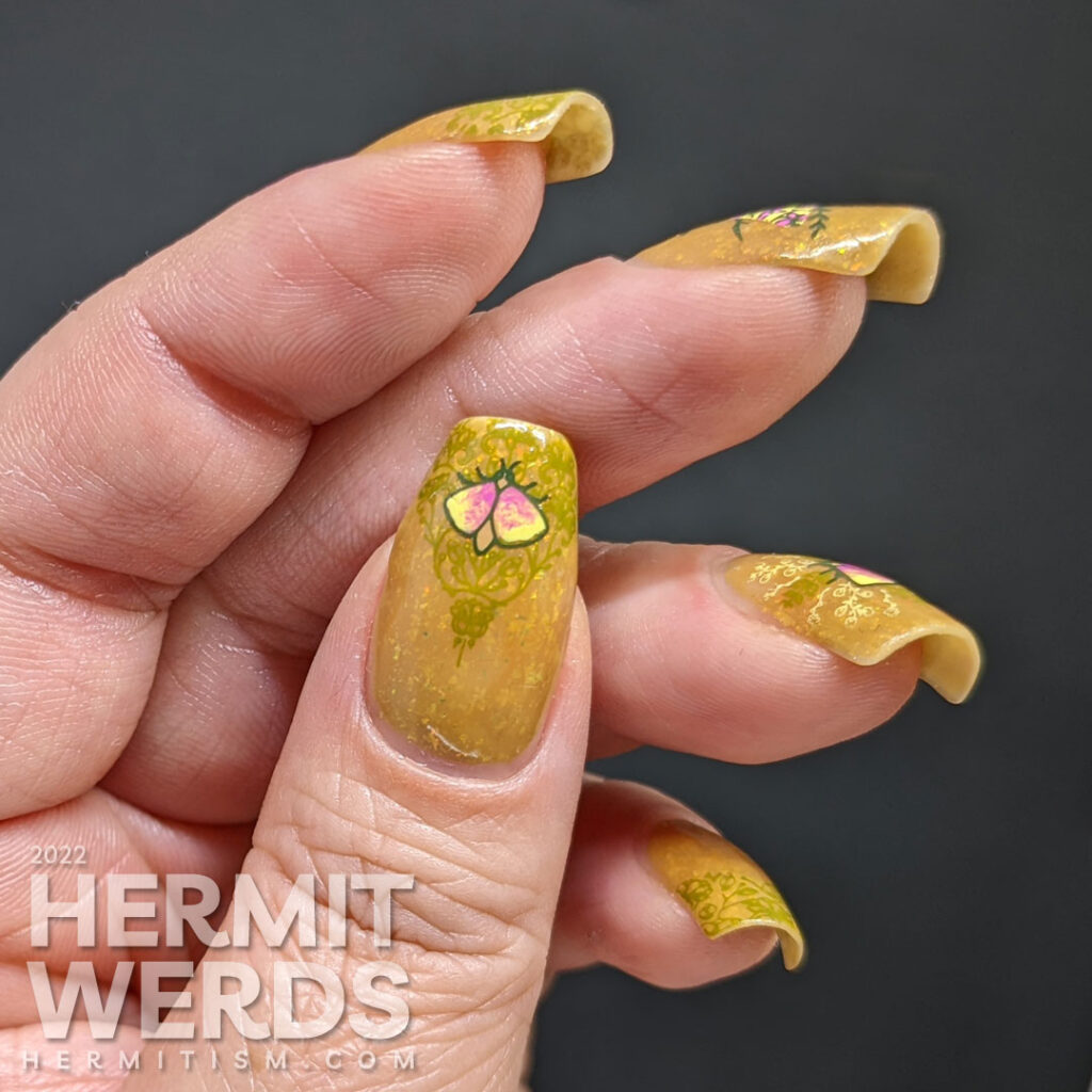 A mustard yellow nail art with whimsical floral patterns and moth stamping images. A ManixMe Springtime Stroll mani.