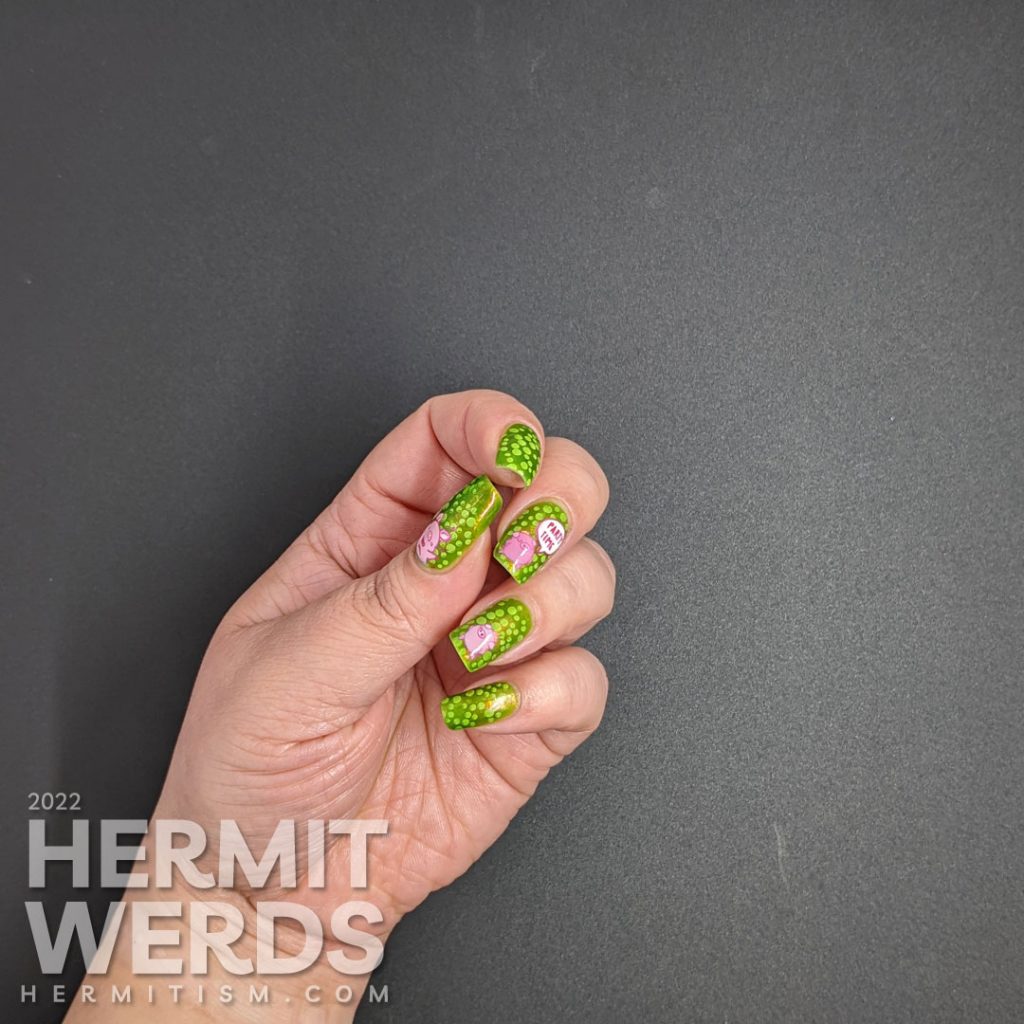 A polka dot pig nail art with party pig reverse stamping decals and polka dots tucked between layers of a bright green jelly polish.