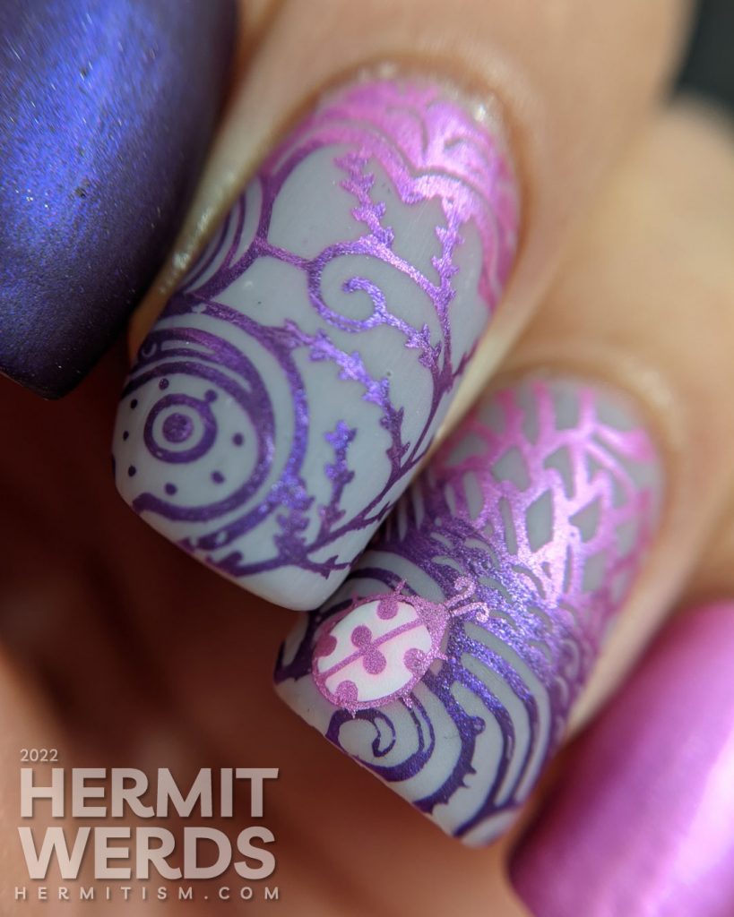 Ladybug nail art with magenta and purple metallic stamping polishes in magically wild patterns.