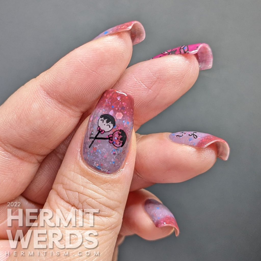 Candy nail art with sweet wrapped treats on a purple and dark pink thermal polish stuffed with glitters.