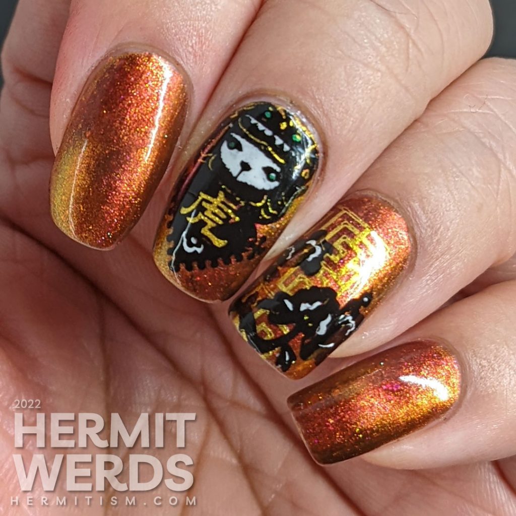 A lovely red, pink, and gold multichrome magnetic nail polish paired with tiger paper cut stamping images for a Year of the Tiger zodiac mani.