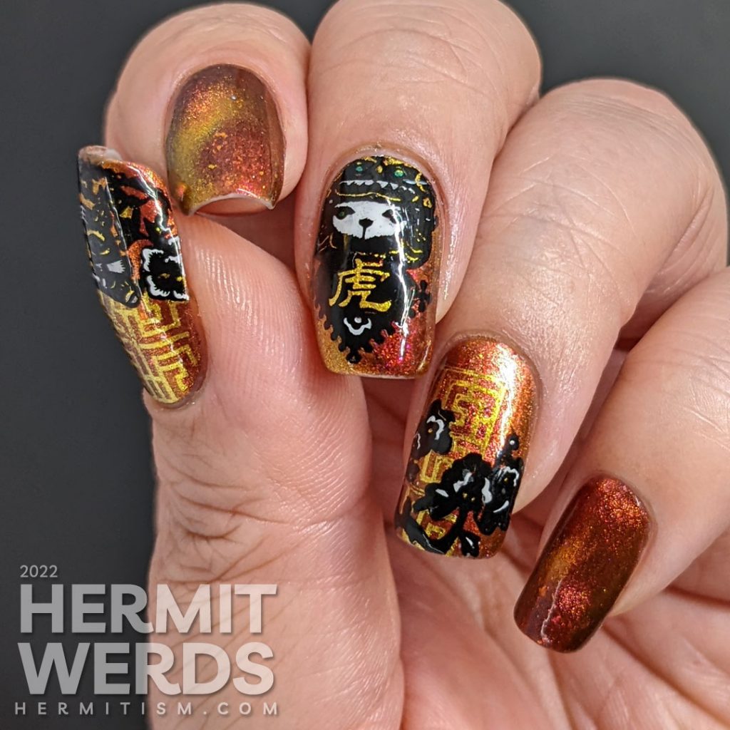 A lovely red, pink, and gold multichrome magnetic nail polish paired with tiger paper cut stamping images for a Year of the Tiger zodiac mani.