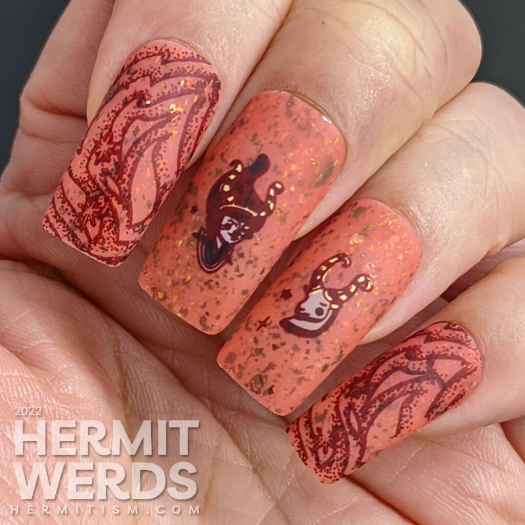 A fiery brick rose crelly nail art with red zodiac stamping images of stylized goat and girl with horn and the symbol for Aries.