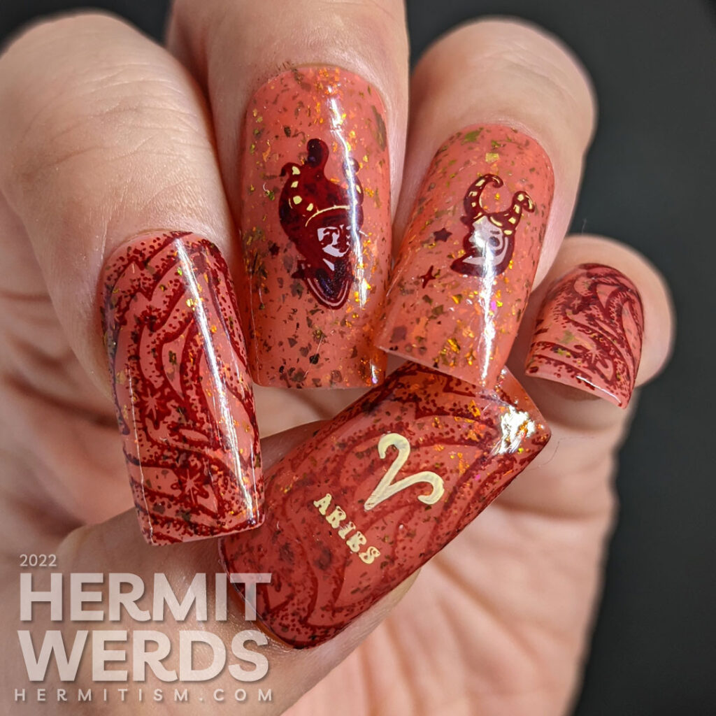 A fiery brick rose crelly nail art with red zodiac stamping images of stylized goat and girl with horn and the symbol for Aries.