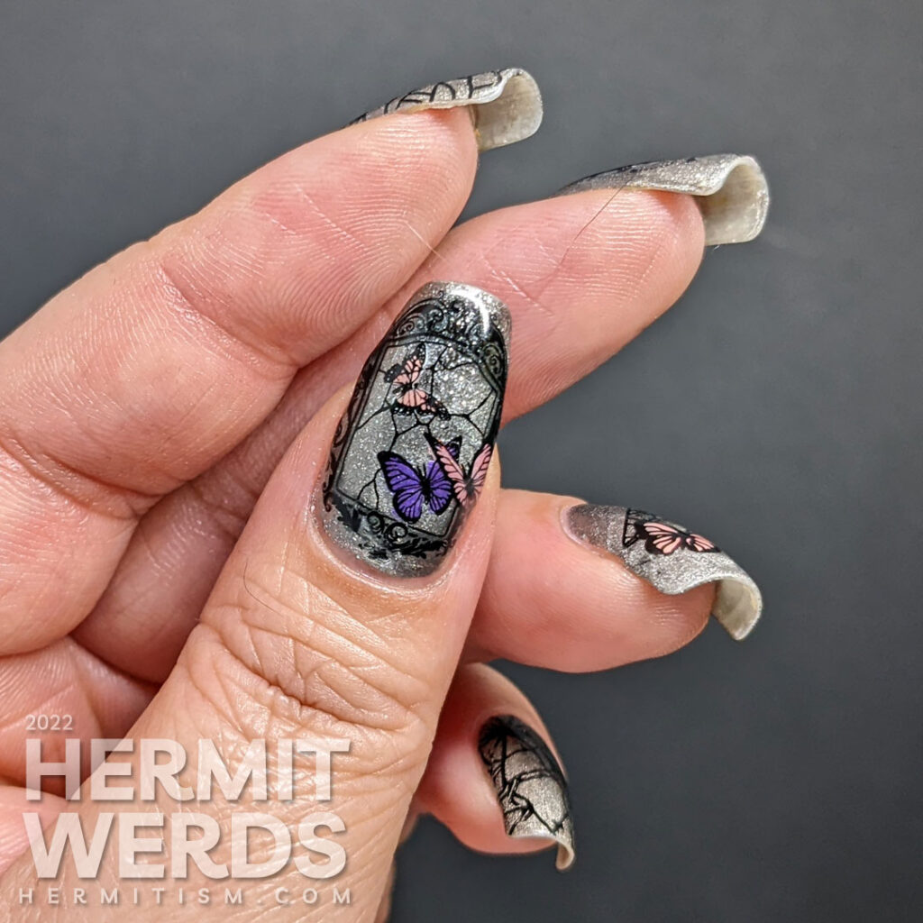 A silver magnetic bad luck nail art with reverse stamping decals of broken mirrors, mirror shards, and butterflies.