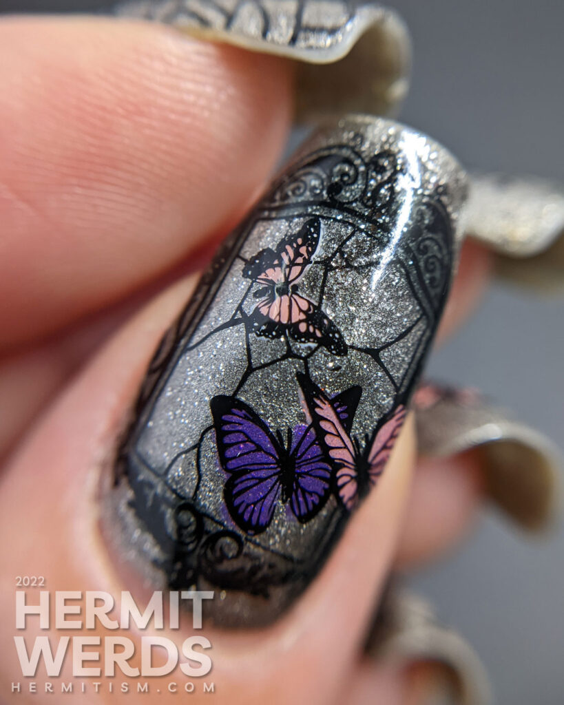 A silver magnetic bad luck nail art with reverse stamping decals of broken mirrors, mirror shards, and butterflies.