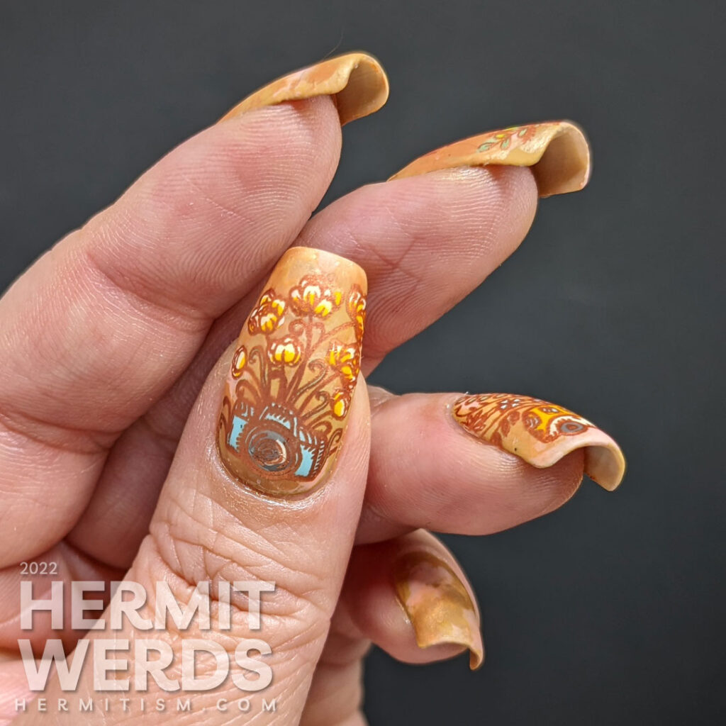 A soft orange smoosh mani with cute bus and camera stamping decals with plants growing out of and around them.