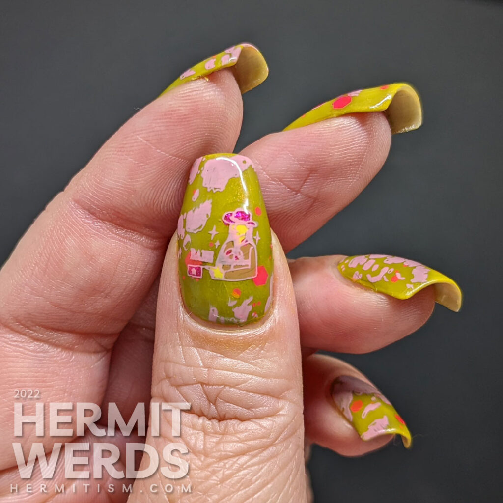 Cowgirl nail art on a green base with pink glitters, pink stamping decals of pink cowhide print, cowboy hat, and cowgirl with a "bang" flag.