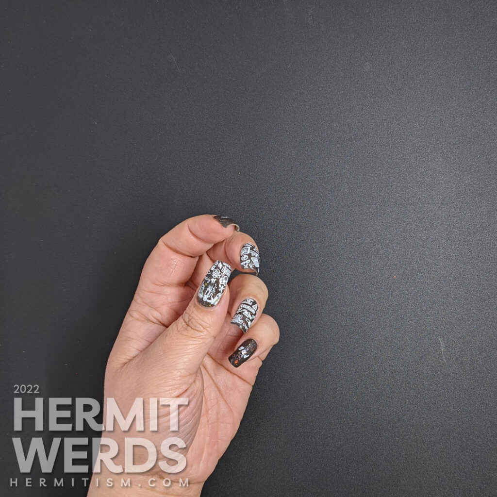 Back to school nail art with chalkboard stamping images about education topics (esp science) on a charcoal rainbow flakie background.