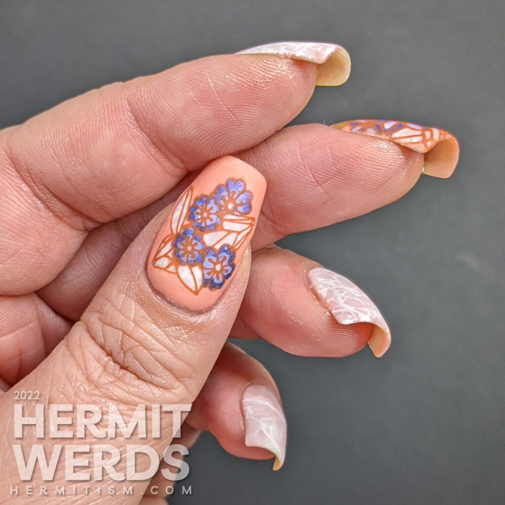 Quartz crystal nail art in soft corals and whites with a reverse stamping images of quartz crystals with purple spring flowers.