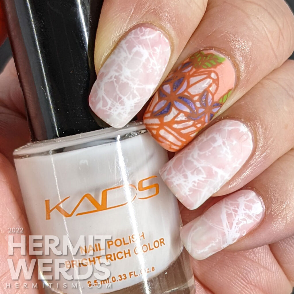 Quartz crystal nail art in soft corals and whites with a reverse stamping images of quartz crystals with purple spring flowers.