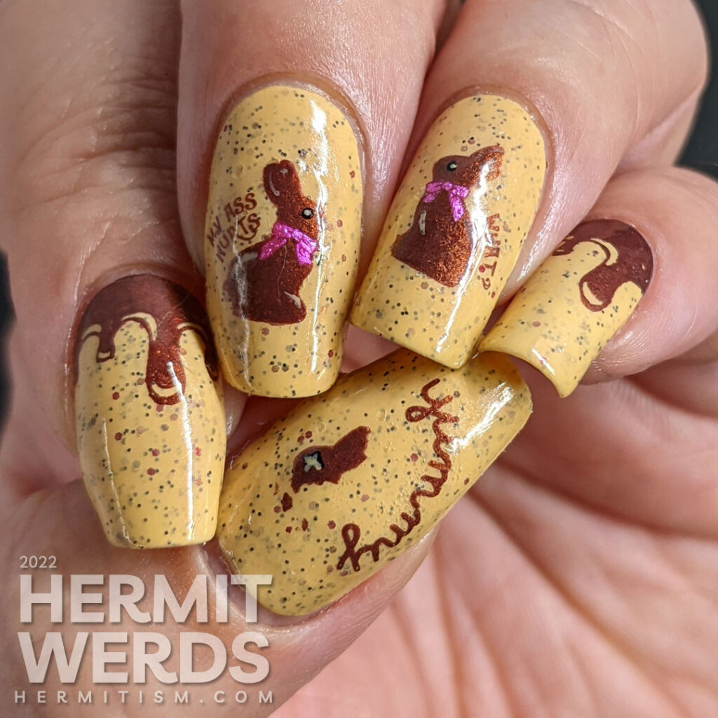 A mustard crelly with small purple and red glitters with chocolate Easter bunny stamping decals who have been munched on top.