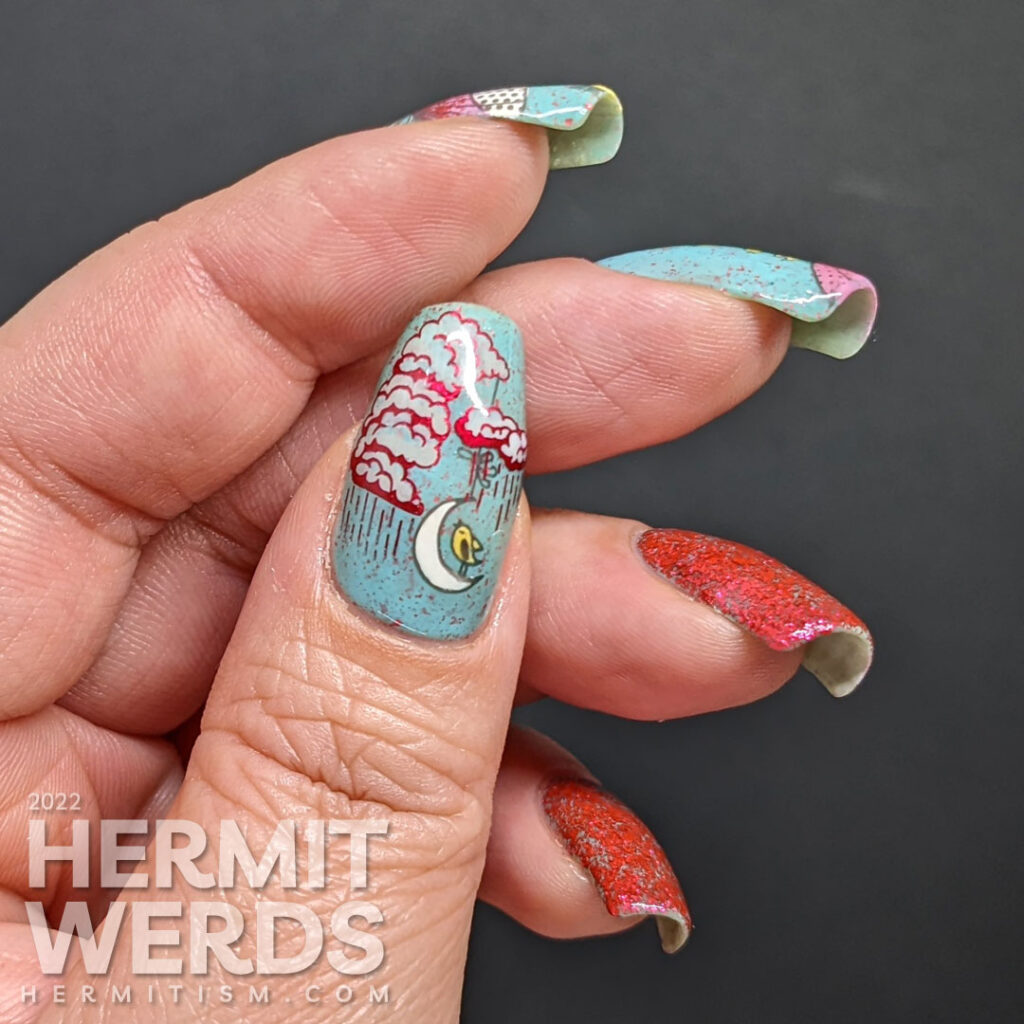 A blue and red nail art with stamping decals of pink umbrellas, singing yellow birds, and rainy clouds and two nails covered in red flakies.