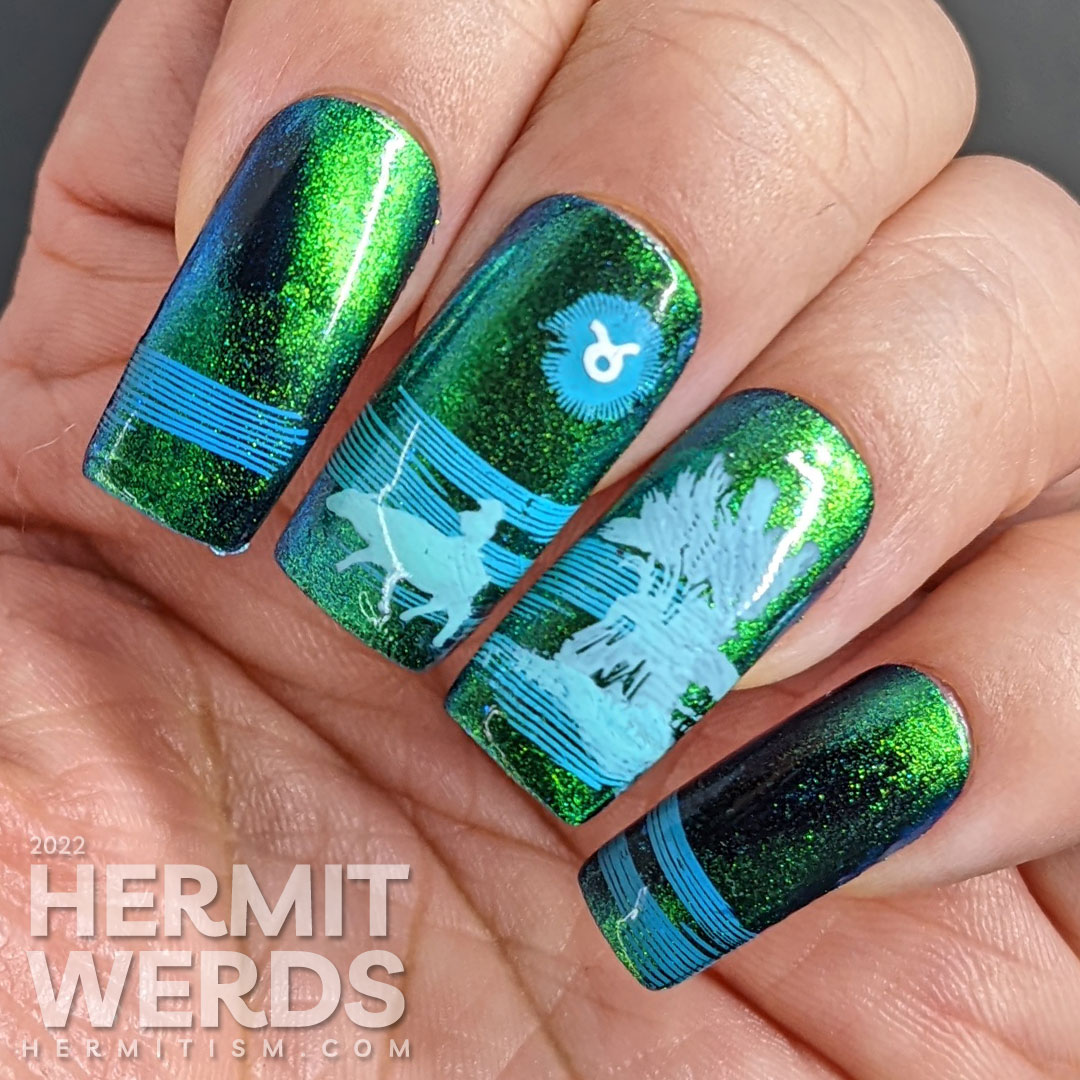 Taurus nail art with a blue/green magnetic polish and stamping decals of oxen, fields, grain, and a Taurus symbol.