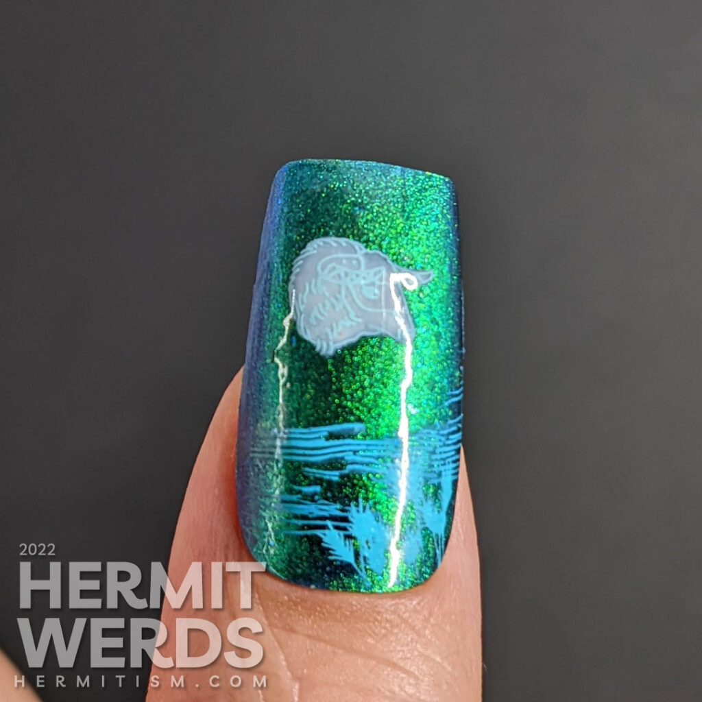 Taurus nail art with a blue/green magnetic polish and stamping decals of oxen, fields, grain, and a Taurus symbol.