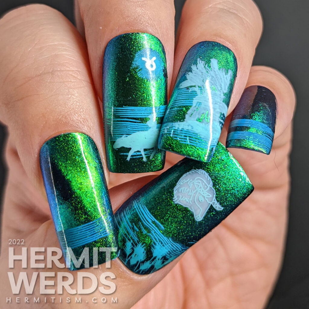 Taurus nail art with a blue/green magnetic polish and stamping decals of oxen, fields, grain, and a Taurus symbol.