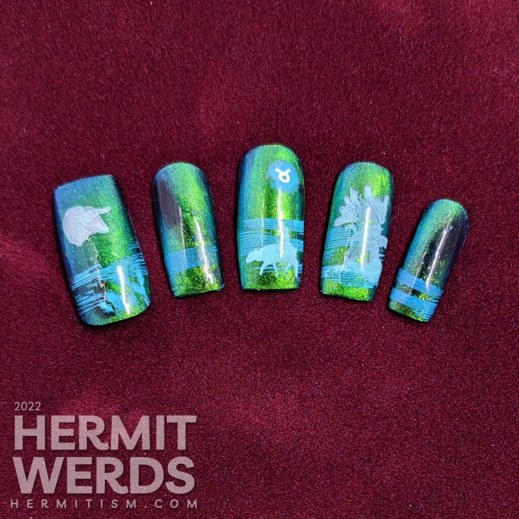 Taurus nail art with a blue/green magnetic polish and stamping decals of oxen, fields, grain, and a Taurus symbol.