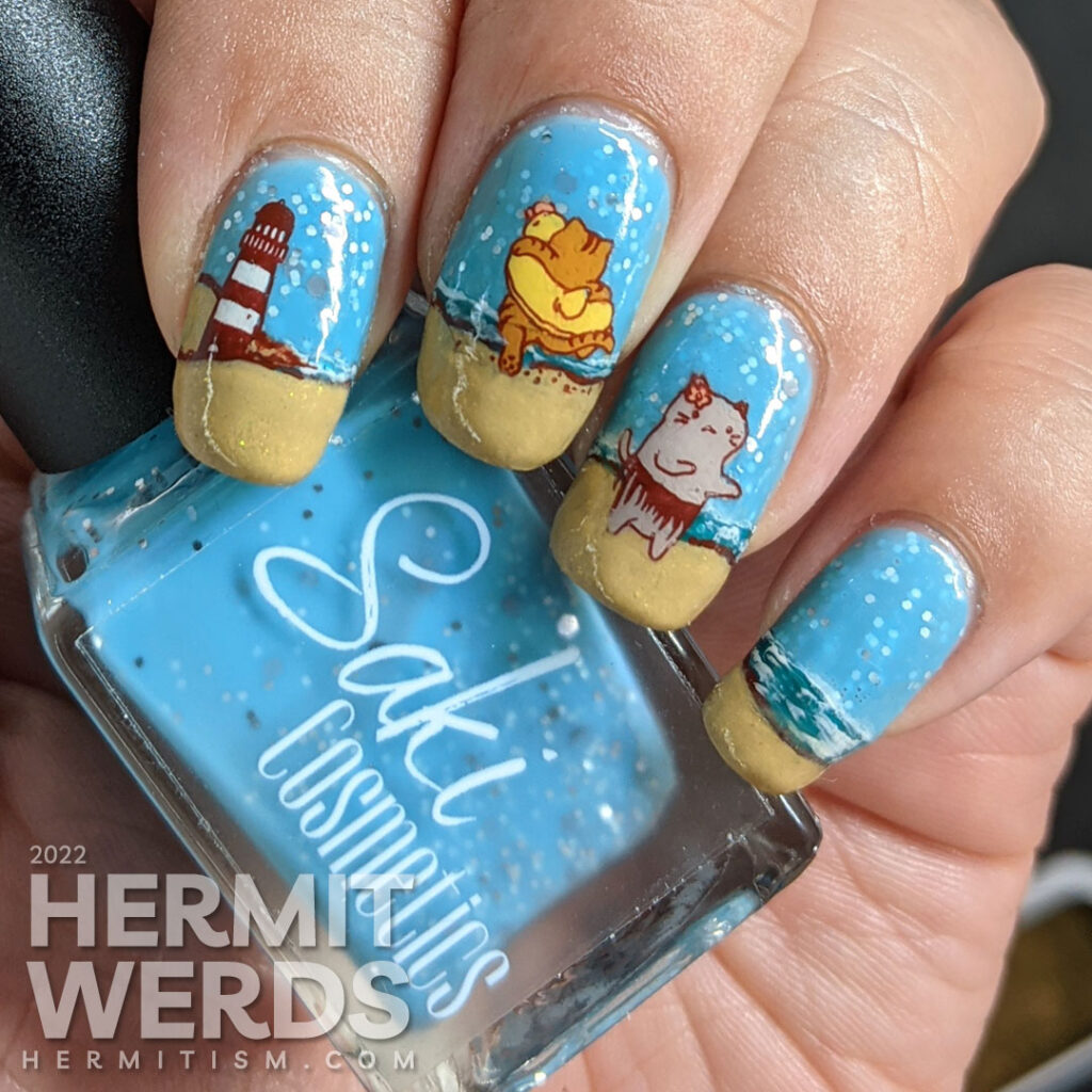 Beach kitty nail art with stamping decals of cute cats playing on a sandy beach and catching some rays. Plus a bonus lighthouse.